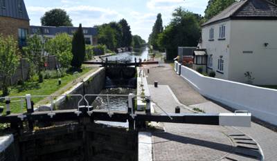 View of top lock with canal stretching into distance and cottage to the right