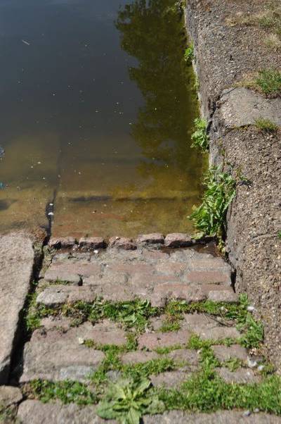 A ramp made of cobbles leads down into water
