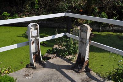 Two white metal posts with the remains of machinery, arranged in a triangle