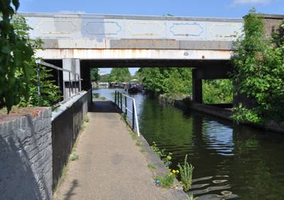 Canal passes under flat painted overbridge