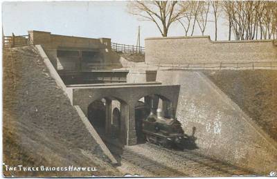 A steam locomotive passes beneath the canal and the road is above